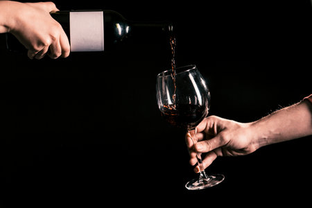 crop hands pouring wine into glass