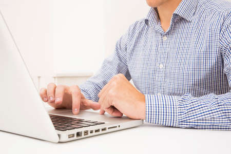 businessman s hand browsing laptop white table