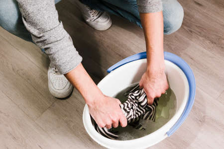 close up man squeezing wet cloth bucketの写真素材