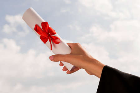certificate with ribbon bow held hand. High quality photoの写真素材