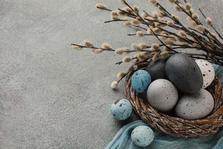 high angle colored easter eggs basket with copy space twigs. High quality beautiful photo concept