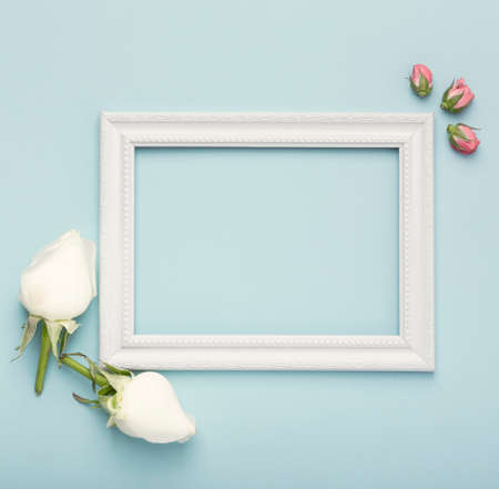 mock up white horizontal empty frame with rosebuds blue background. High quality photoの写真素材