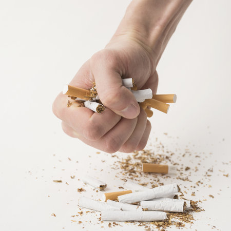 man s fist creasing cigarettes white background. High quality beautiful photo conceptの写真素材