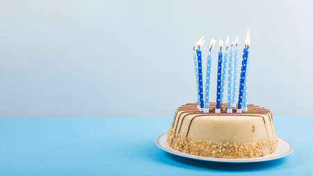 lighted candles delicious cake against blue backdrop. High quality beautiful photo conceptの写真素材