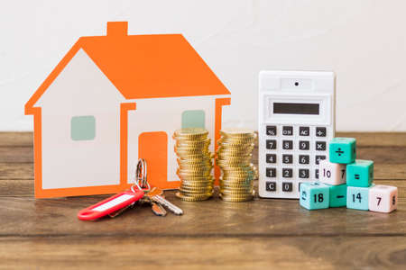house key stacked coins calculator math blocks wooden table. High quality photo