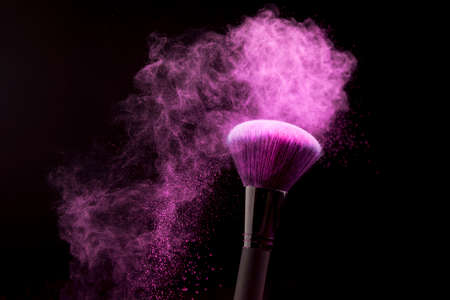 makeup brush with purple powder dust dark background. High quality photoの写真素材