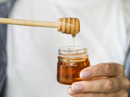 hand holding sweet honey jar. High quality beautiful photo concept