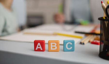 front view letters cubes with defocused tutoring session back.の写真素材