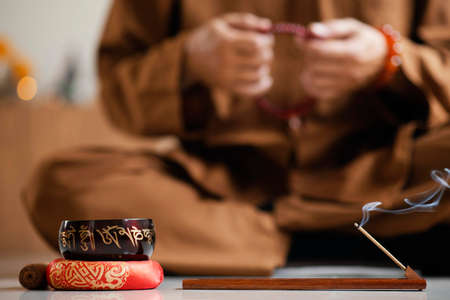 front view defocused man meditating with beads singing bowl. High quality photoの写真素材