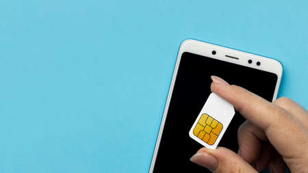 top view hand holding sim card with smartphone copy space. High quality photoの写真素材