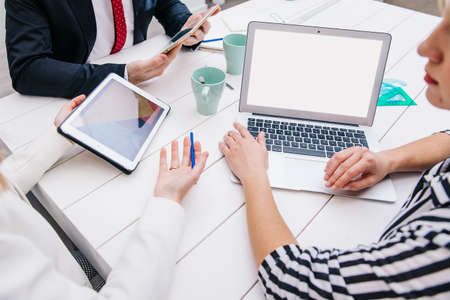 colleagues with devices working desk. High quality photoの写真素材