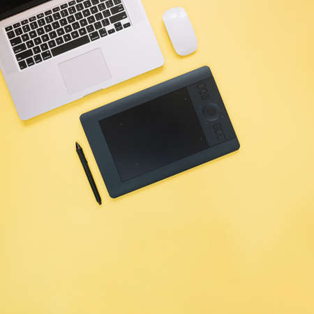 elevated view graphic digital tablet laptop yellow background. High quality photoの写真素材