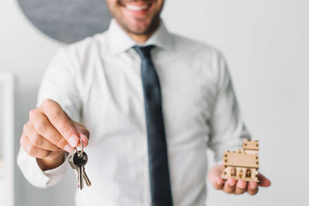 crop real estate agent with keys house. High quality photo