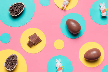 overhead view easter eggs rabbit choco chips round frame pink background. High quality photo