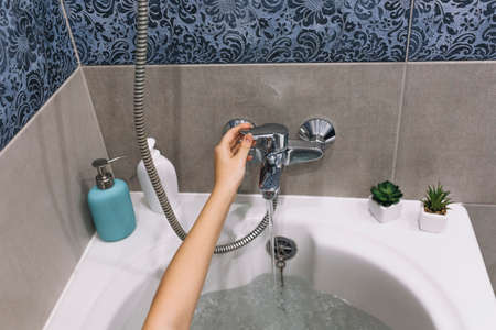 crop hand touching bath tap. High quality photoの写真素材