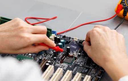 high angle female technician repairing computer motherboard. High quality photoの写真素材