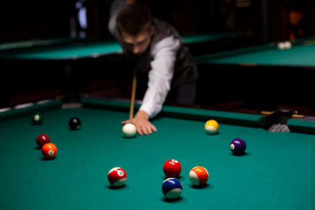 medium shot guy with pool cue playing billiard. High quality photoの写真素材