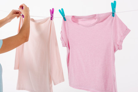 woman fixing t shirts clothesline with clothes pins. High quality photoの写真素材
