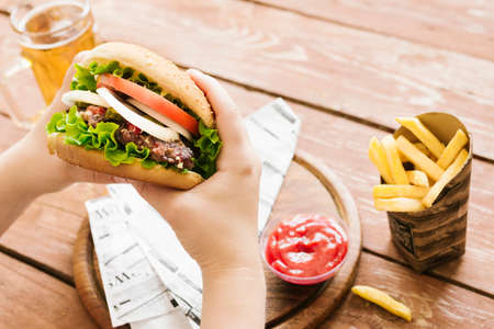 high angle hands holding burger burger fries. High quality photoの写真素材