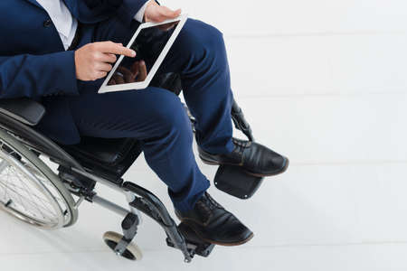 close up businessman s hand wheel wheelchair. High quality photoの写真素材