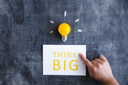 close up hand pointing finger think big with light bulb chalkboard. High quality photoの写真素材