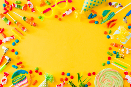high angle view candies lollipops candles party blower yellow surface. High quality photoの写真素材