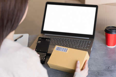 high angle woman looking up bar code box she s holding. High quality photoの写真素材