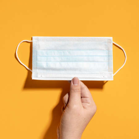 flat lay hand holding medical mask. High quality photoの写真素材