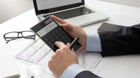 sideways business man calculating finance numbers. High quality photo