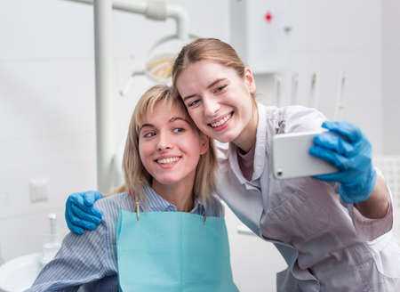 portrait dentist taking selfie with patient. High quality photoの写真素材