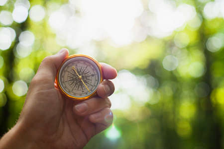 hand holding compass blurred background. High quality photoの写真素材