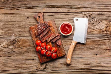 grilled beef steak fresh tomato sauce cutting board. High quality photoの写真素材