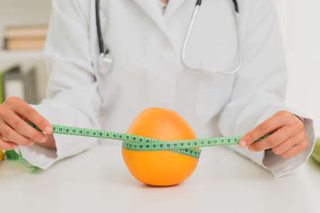 close up nutritionist measuring orange. High quality photoの写真素材