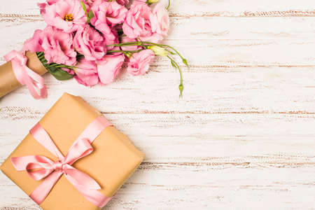 wrapped pink eustoma flower gift box white old table. High quality photoの写真素材