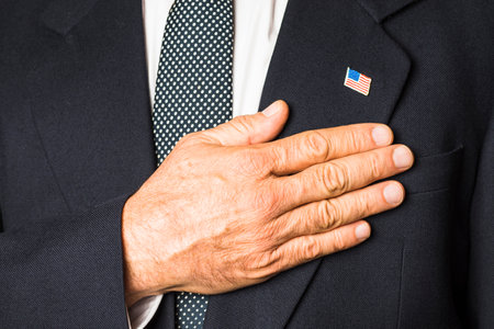 patriotic man usa badge his black coat touching hand his chest. High quality photoの写真素材