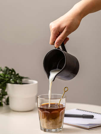 person pouring cream coffee glass. High quality photoの写真素材