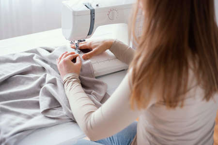 high angle female tailor with sewing machine fabric. High quality photoの写真素材