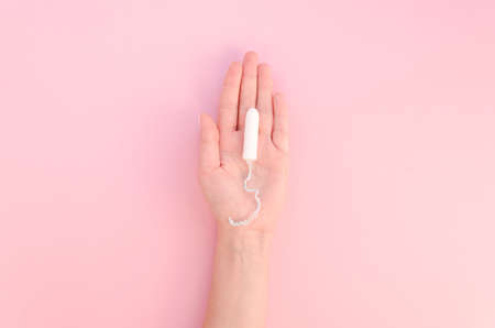 hand holding tampon pink background. High quality photoの写真素材