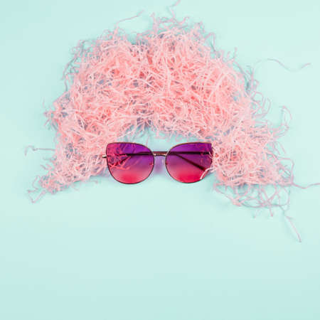 pink shredded paper wig sunglasses mint background. High quality photoの写真素材