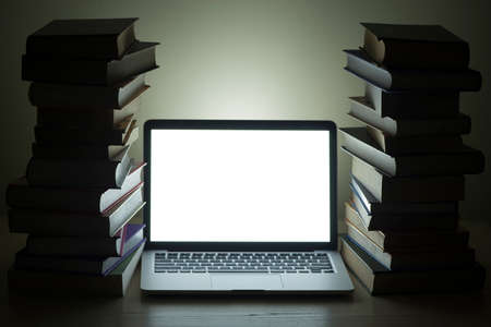 laptop dark stacked books. High quality photoの写真素材