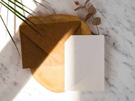 marble background with wooden plate with brown envelope white blank. High quality photoの写真素材