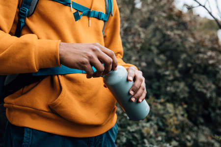 mid section man opening lid water bottle. High quality photoの写真素材