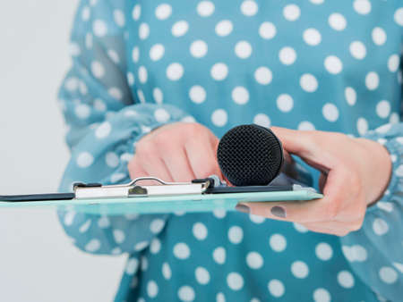 woman holding microphone clipboard. High resolution photoの写真素材