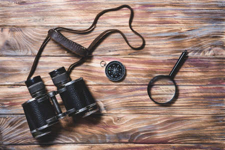 wooden background with binocular compass magnifying glass. High resolution photoの写真素材