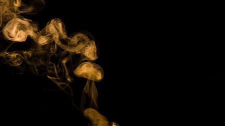 yellow smoke curl black background with copy space writing text. High quality photoの写真素材