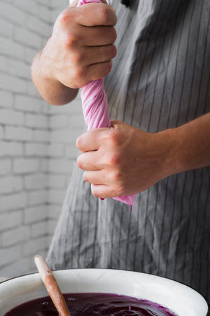 sideways person squeezing cloth from natural dye