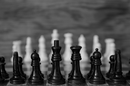 Chess chips in black and white initial formation with textured backgroundの写真素材