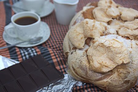 Table with a full service with a typical Valencian mona de Pascua (Easter), coffee and chocolate for...