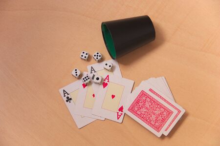 The four aces of the poker cards next to six dice of points and the rest of the deck without...