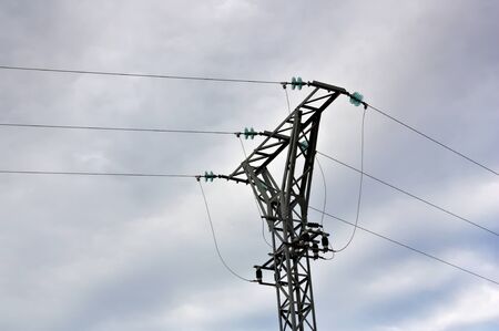 Part of a tower that supports the cables that bring us the flow of high voltage electricity , behind...